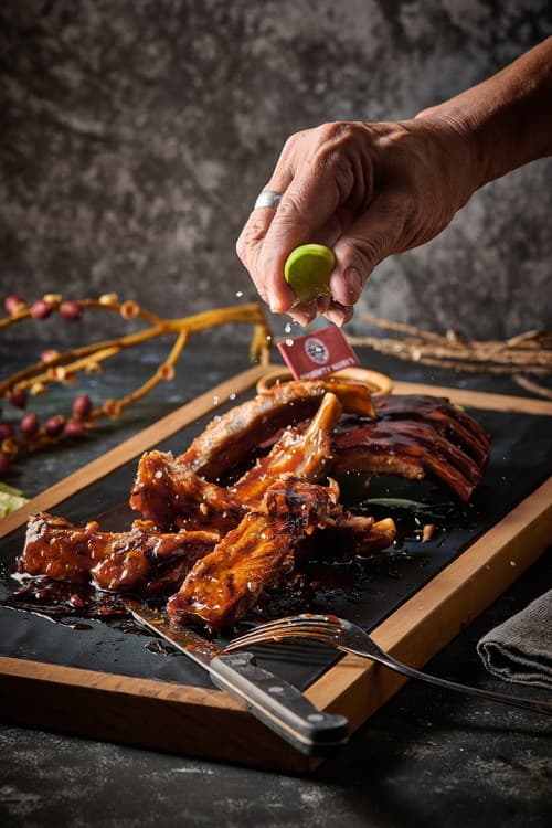 A rack of smoked BBQ spare ribs glistening with sauce